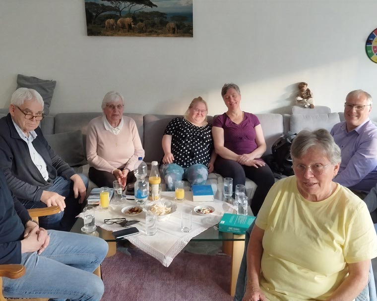 Menschen sitzen in einem Hauskreis zusammen