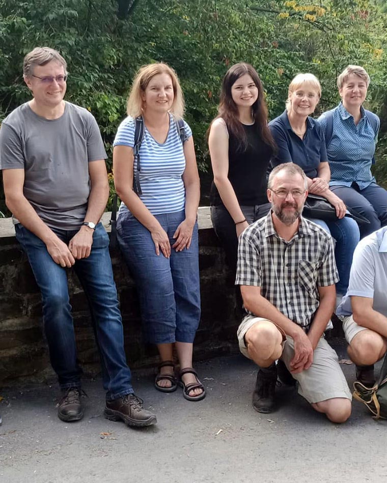 Eine Wandergruppe macht gemeinsam Pause im Grünen
